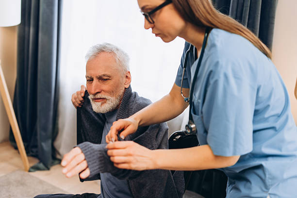 istock Nurse assisting senior man getting dressed at home 2238545762