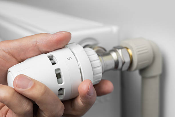 istock Save energy: close up of Hand Adjusting Heating Thermostat, one hand operates the temperature controller radiator 2238545957