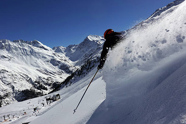 Male skier riding in the deep snow on a sunny day in the skiresort of St. Anton am Arlberg in Tirol, Austria