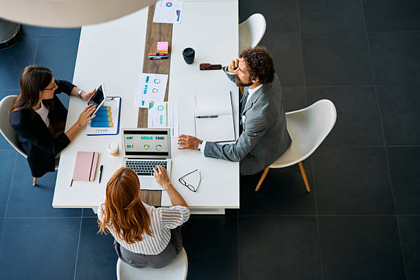 istock Business people collaborating in corporate office meeting analyzing data 2238546744