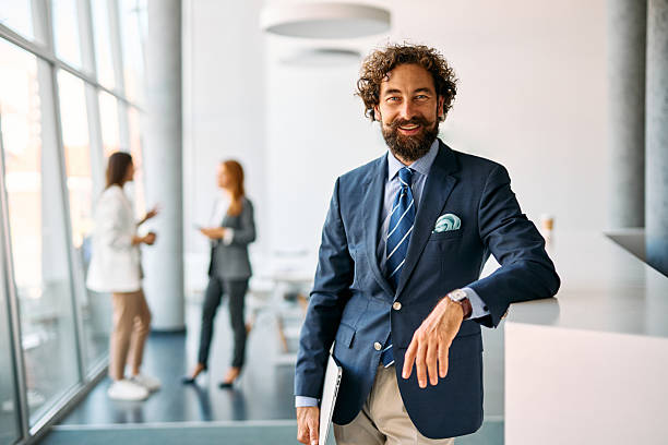 istock Businessman smiling in modern office with blurred colleagues 2238546992