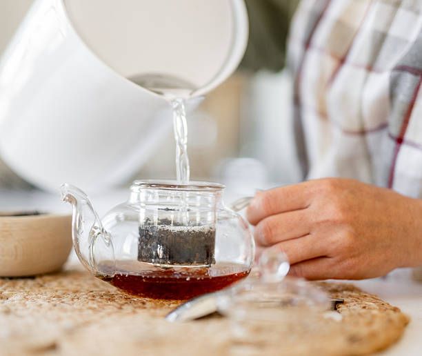 istock Woman Pouring Tea Into Mug 2238547086