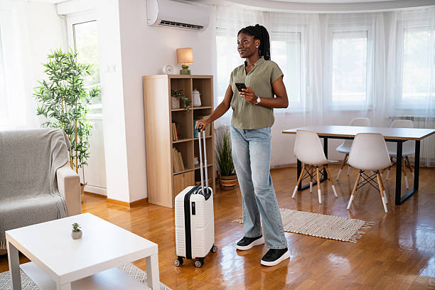 istock Young Black woman arriving at her accommodation with suitcase in hand 2238549900