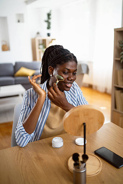 istock Young black woman using a jade roller on her face at home 2238550288