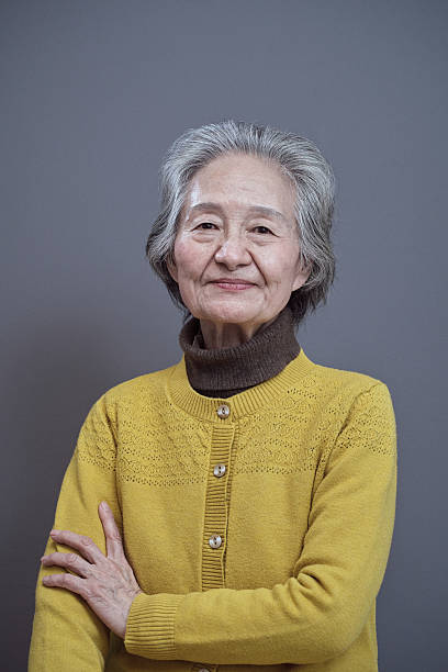 istock Mature asian woman smiling with arms folded 2238554052