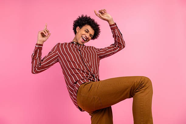 istock Cheerful fashionable man with joyful expression gestures energetically against pink background, embracing vibrant casual style 2238554288
