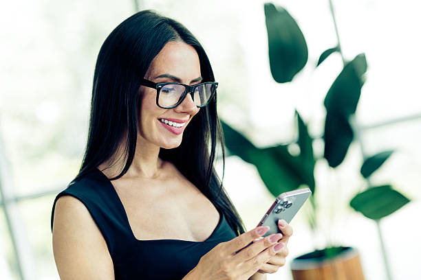 istock Confident businesswoman using a smartphone in a modern office setting, displaying professionalism and focus in her career. 2238555168