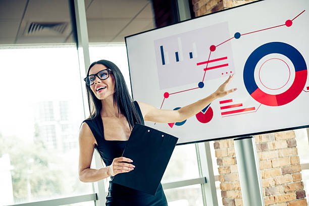 istock Confident businesswoman presenting analytics on screen in modern office 2238555189