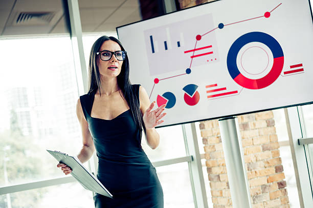 istock Confident Businesswoman Leading a Presentation in a Modern Office Environment Displaying Analytics on a Screen 2238555190