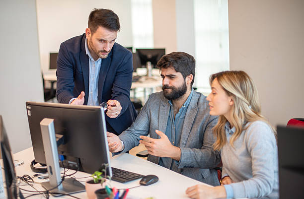 istock Business people collaborating at computer and discussing project during office meeting 2238555896