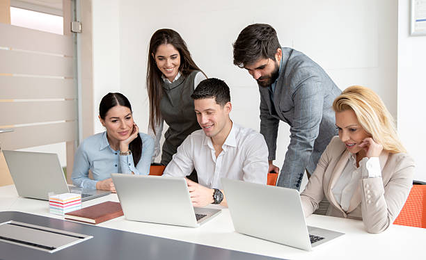 istock Group of business people gathered around young manager working on laptop developing strategy 2238556126