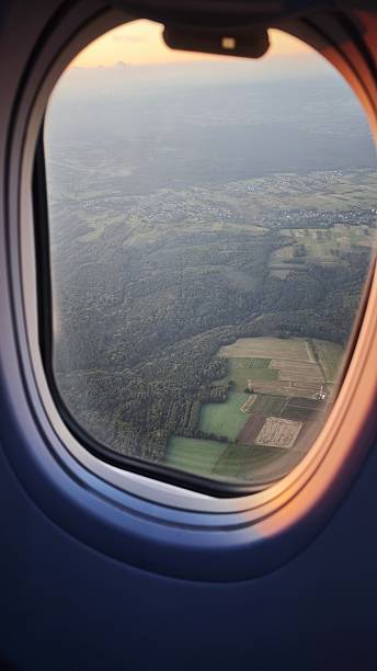 istock Aerial view of patchwork fields and forests seen through an airplane window at sunset 2238560679