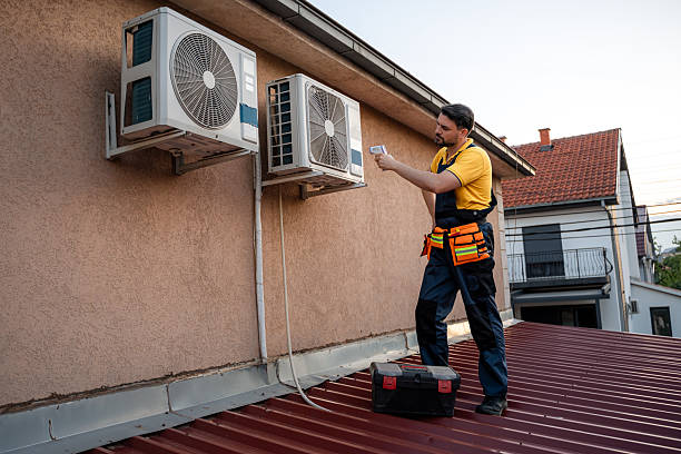 istock Professional technician repairs air conditioning units on a residential rooftop in the evening light 2238560821