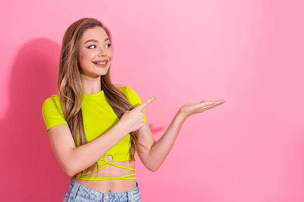 istock Lovely Young Female Gesturing with Cheerful Expression and a Stylish Look in Bright Summer Outfit on Pink Background 2238560962