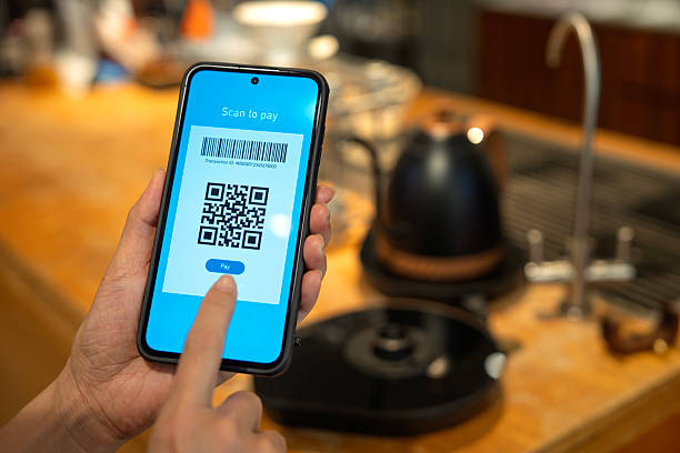 istock Person scanning QR code for mobile payment at cafe counter 2238560969