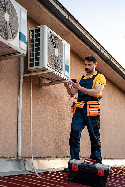 istock Technician performs maintenance on air conditioning unit on rooftop during late afternoon 2238561235