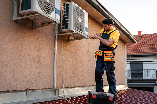 istock Technician repairs air conditioning units on a rooftop during late afternoon 2238561244