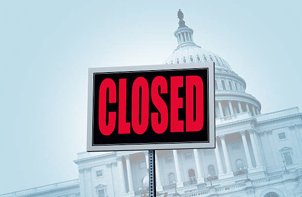 A closed sign in front of the United States Capitol building.