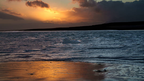 istock A large chunk of ice floats by the beach at sunset 2238562690