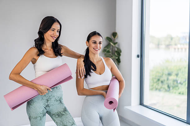 istock Two women holding yoga mats ready for workout 2238563415