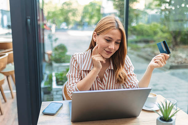 istock Beautiful Woman Using E-Commerce App with Credit Card in Hand 2238565100