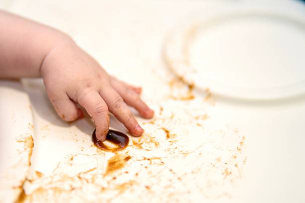 istock child's hand smearing brown messy substance on a white table surface 2238567468
