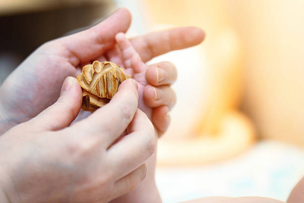 Infant palm massage for sensory development using a wooden spiked ball.
