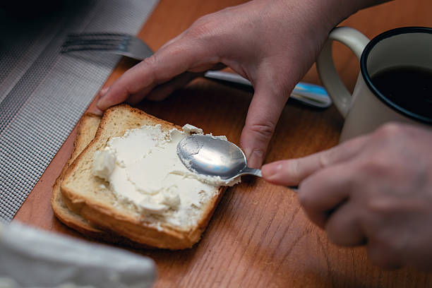 istock Spreading cottage cheese on crispy toast with a metal teaspoon for breakfast 2238567951
