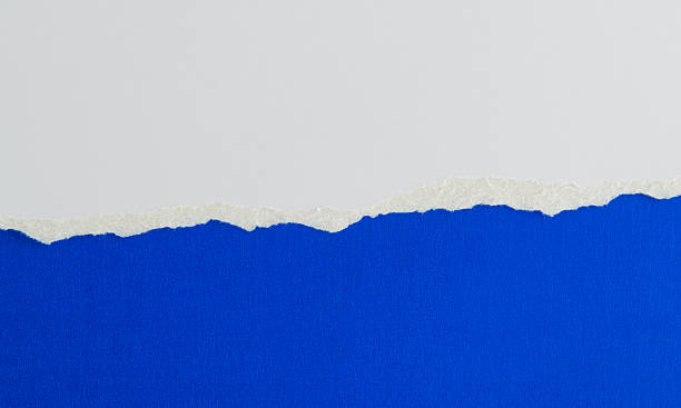 istock Tear white paper to reveal the blue background 2238569580
