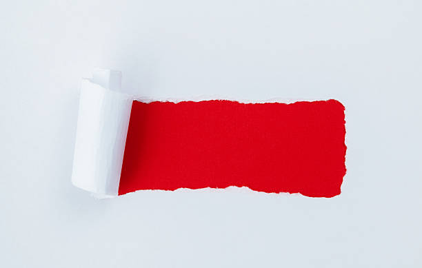 istock Torn white paper revealing red background 2238569615