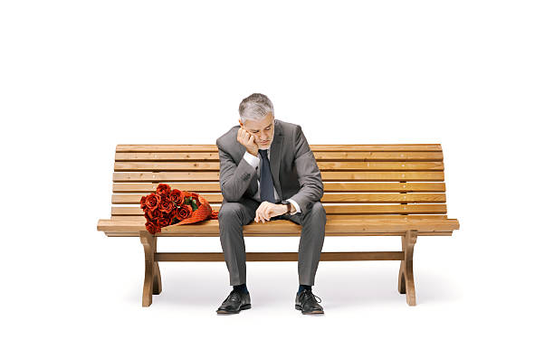 Young caucasian man sitting alone on riverbank.