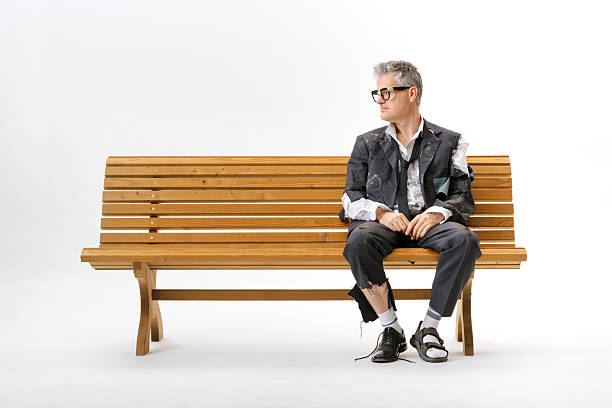 istock Unemployed homeless businessman sitting on a bench 2238570500