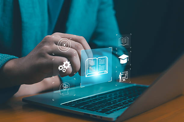 istock Hand pointing at virtual open book icon on laptop, symbolizing e-learning, online education, digital knowledge, corporate training, and innovation for modern business and academic success. 2238571159