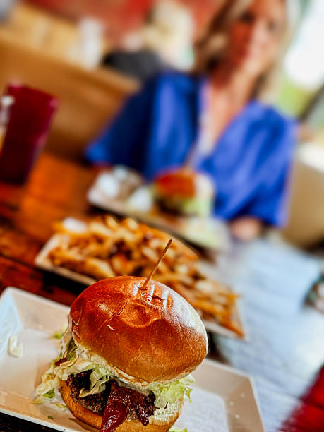 Juicy Double Cheeseburger with Fresh Vegetables and Crispy Fries Served on Wooden Board