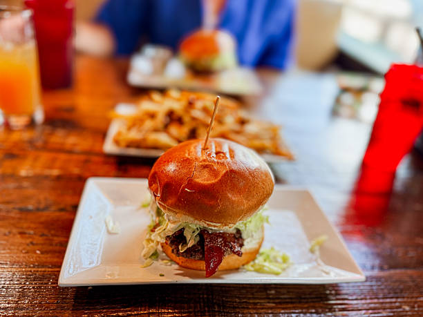 Classic Bacon Burger with Fresh Lettuce and Crispy Fries on Rustic Table