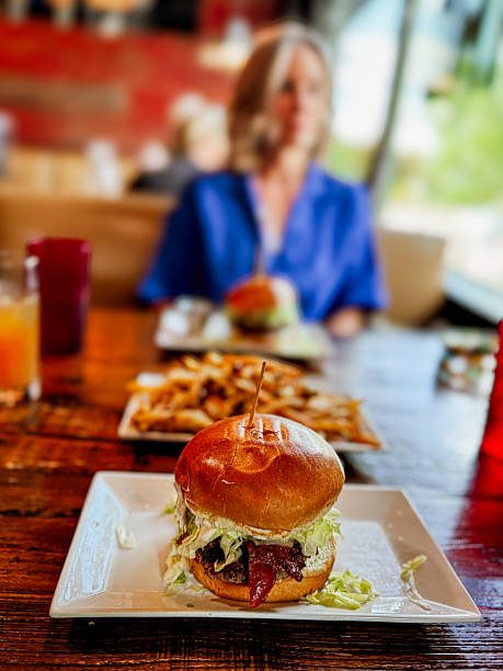 istock Classic Cheeseburger with Crisp Lettuce, Tomato, and Golden Fries on Rustic Table 2238574964