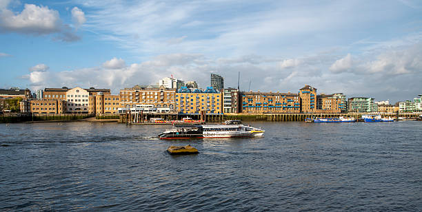Old boats by the river Thames, with modern buildings in Chelsea London