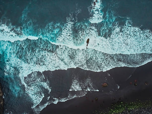 istock Drone view above a black sand beach from Atlantic Ocean with foamy white waves breaking on it. El Ancon Beach in Tenerife, Spain 2238578824
