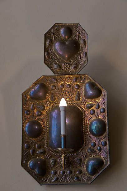 Beautiful decorative wall sconce with intricate designs and glowing candle light in a cozy indoor setting