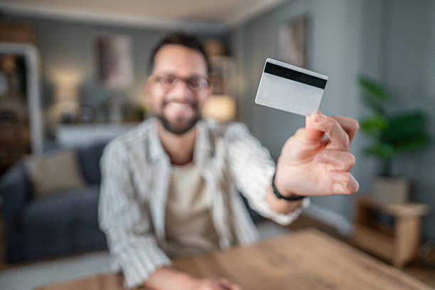 istock Man smiling and holding credit card displaying payment concept 2238582957