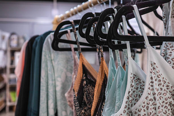 istock Clothing display with various garments hanging on black hangers. 2238584408