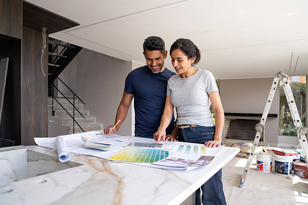 istock Couple remodeling their house and looking at a sketch on a digital tablet 2238588111