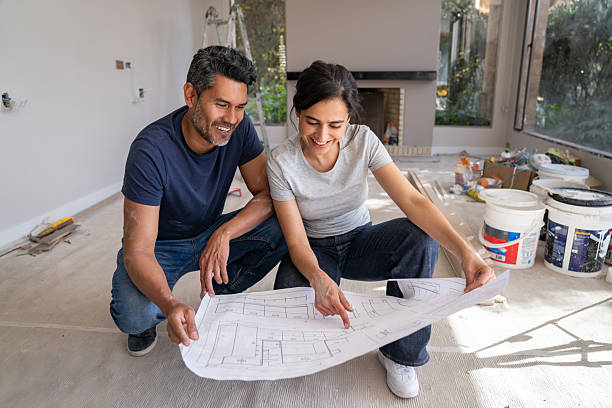 istock Loving couple looking at a blueprint while renovating their house 2238588131