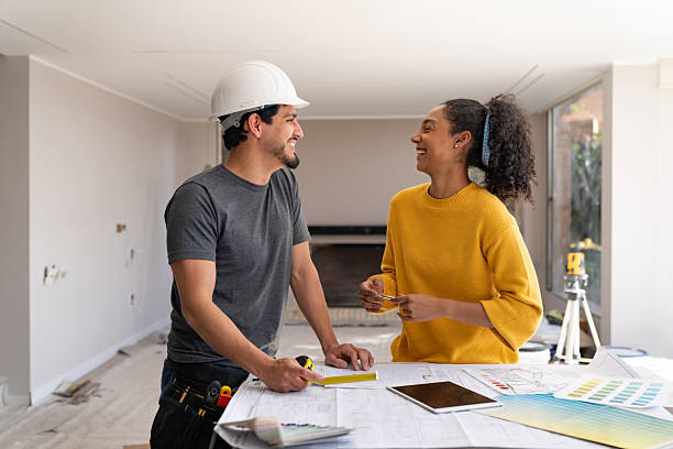 istock Happy construction worker laughing with an interior designer while remodeling a house 2238588141