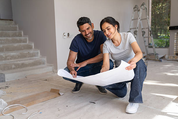 istock Happy couple looking at a blueprint while remodeling their house 2238588153