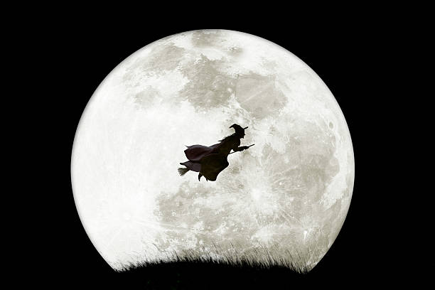 istock Halloween Witch Flying In Front Of A Rising Full Moon 2238588445