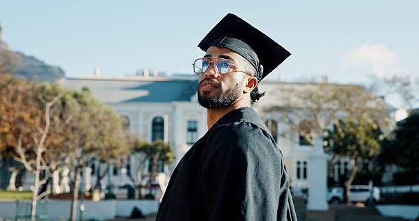 istock Thinking, university and man graduate with education achievement, success or future vision. Ideas, scholarship and male student with graduation for studying, learning or award on college campus. 2238589828