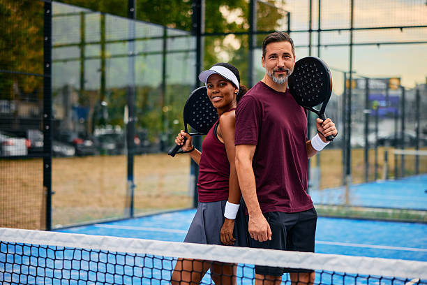 istock Mixed age couple holding padel rackets on blue court 2238589932