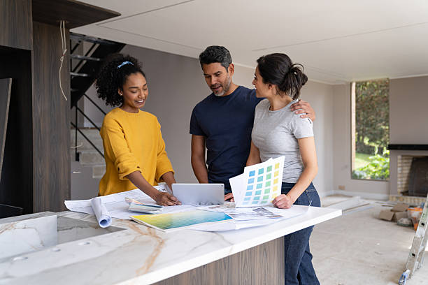 istock Interior designer talking to a couple while renovating their house 2238592457