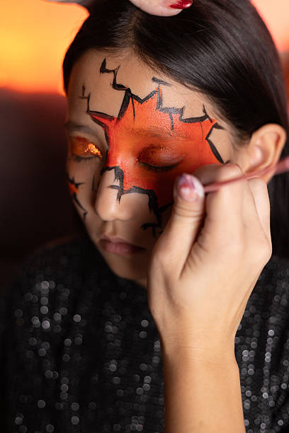 istock person is meticulously applying face paint,creating a cracked effect with 2238595299